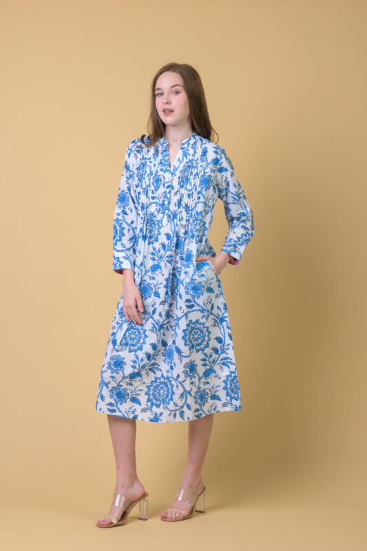 Model wearing a blue and ivory floral shirt dress in a studio